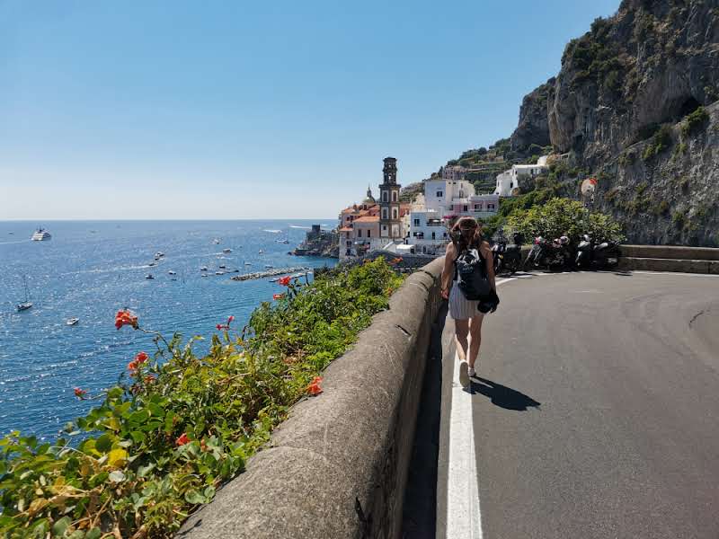 La carretera serpentea junto al mar, con Amalfi de fondo.
