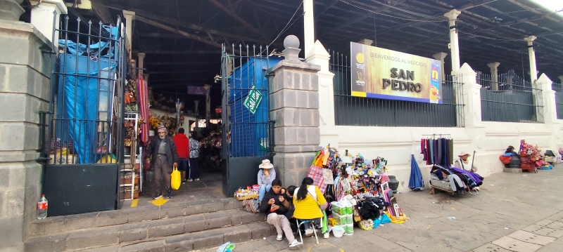 Vendedores indígenas almuerzan a la puerta del Mercado de San Pedro, en Cuzco.