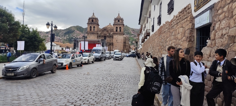 Niños con uniformes escolares juegan en las aceras de la Calle Santa Clara, con la Iglesia de San Pedro al fondo,