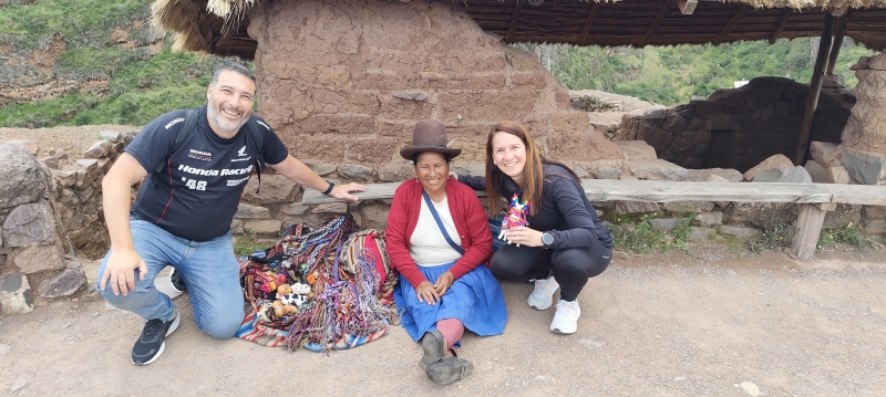 Una mujer india vende sus artesanías en lo alto de las ruinas de Pisac